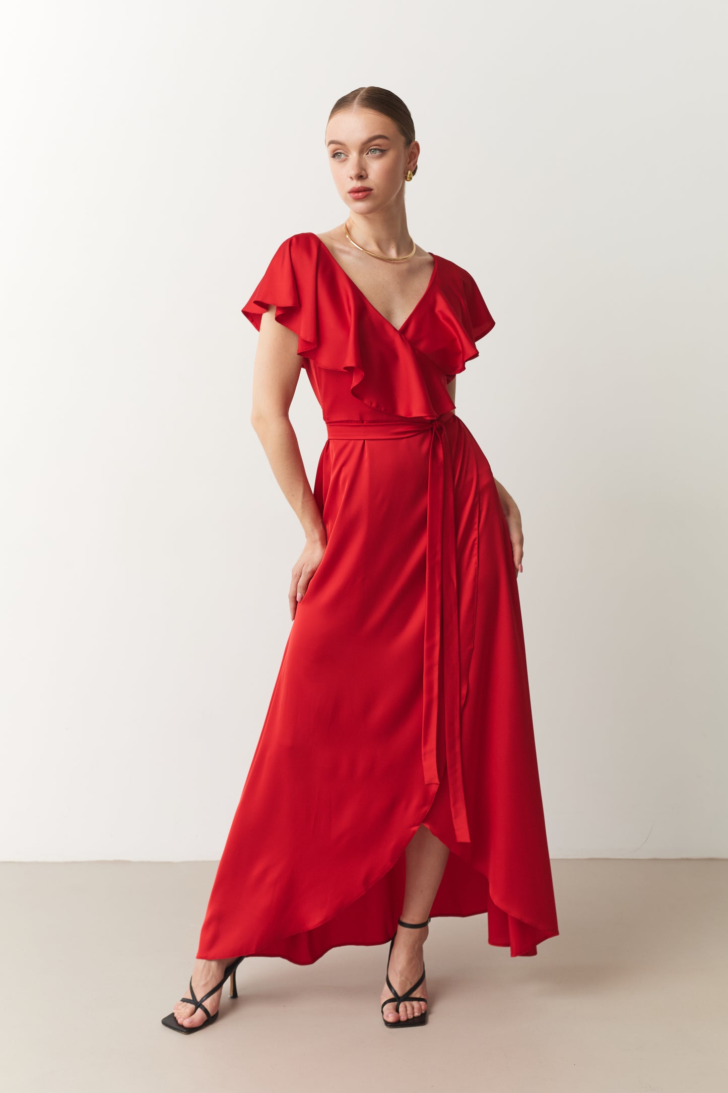 Woman wearing a red dress with ruffled top on a white background